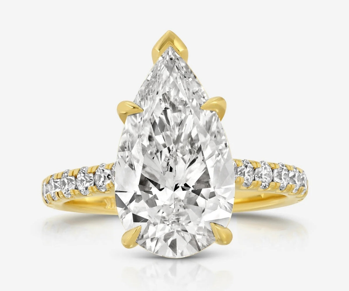 Front view of the TOVAA Moissanite Pavé Ring featuring a large pear-cut center stone and pavé diamond band in yellow gold.