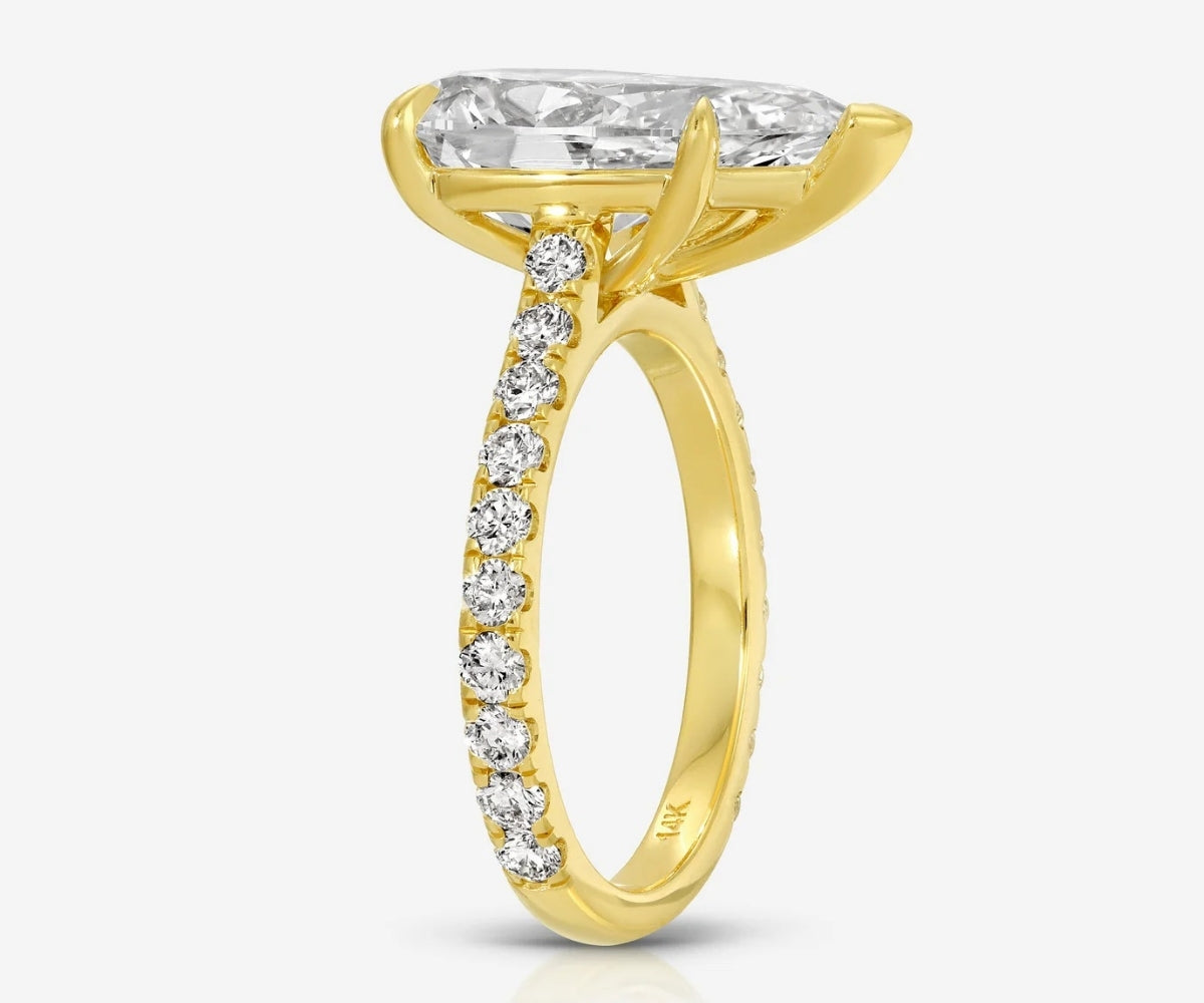 Side profile of the TOVAA Moissanite Pavé Ring highlighting the elevated pear-cut stone and pavé-set band in yellow gold.